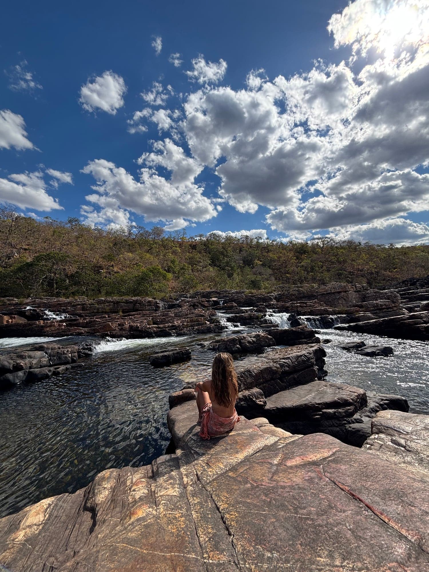 Sitting at the edge of the falls in the chapadas, looking out over the water.